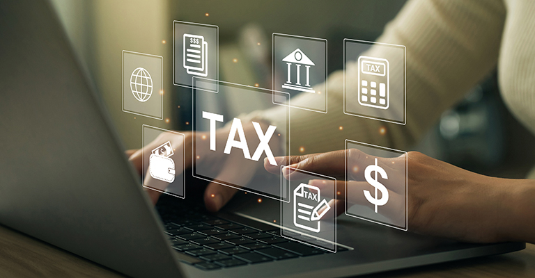Hands typing on a laptop with digital tax-related icons floating above the keyboard, to symbolize estate tax planning