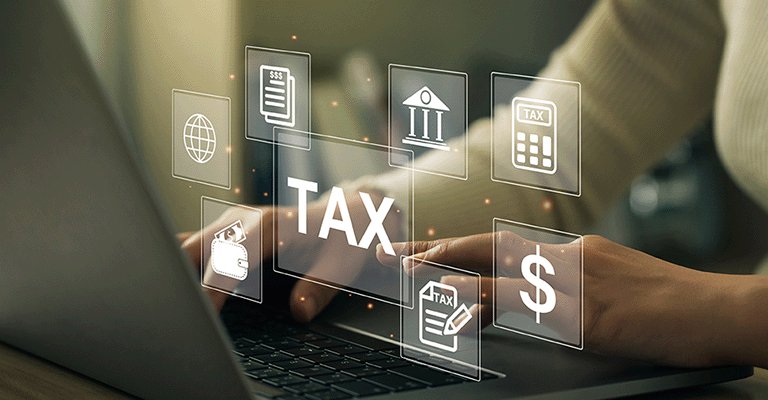 Hands typing on a laptop with digital tax-related icons floating above the keyboard, to symbolize estate tax planning